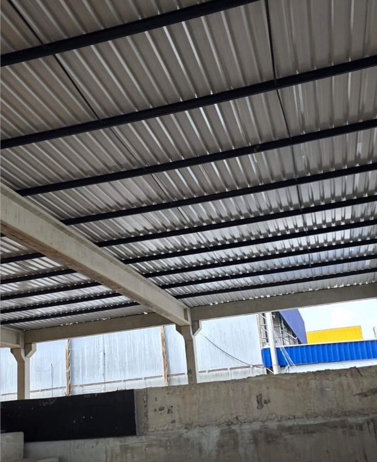 Cobertura de telhas metálicas e vigas de aço instalada em galpão