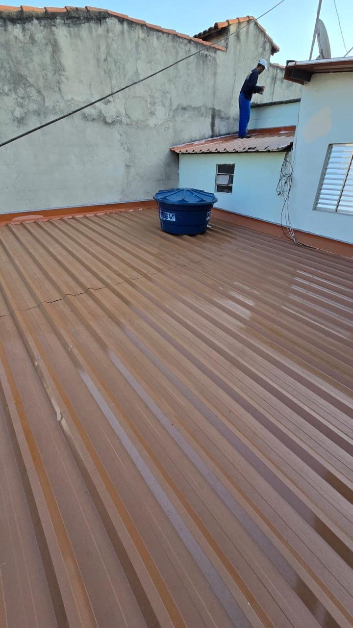 Telhado metálico marrom em residência, com calhas e rufos